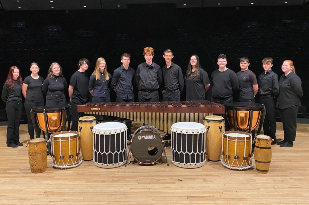 Group of students standing on the JMHS CPA stage in back of a xylophone.